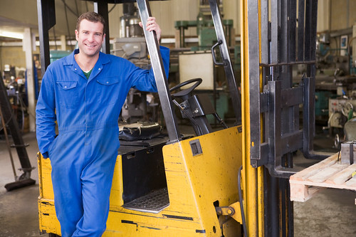 worker standing with forklift